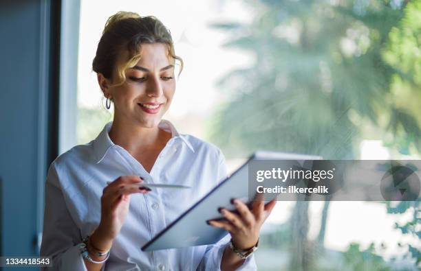 businesswoman writing on digital tablet using digitized pen - 署名 個照片及圖片檔