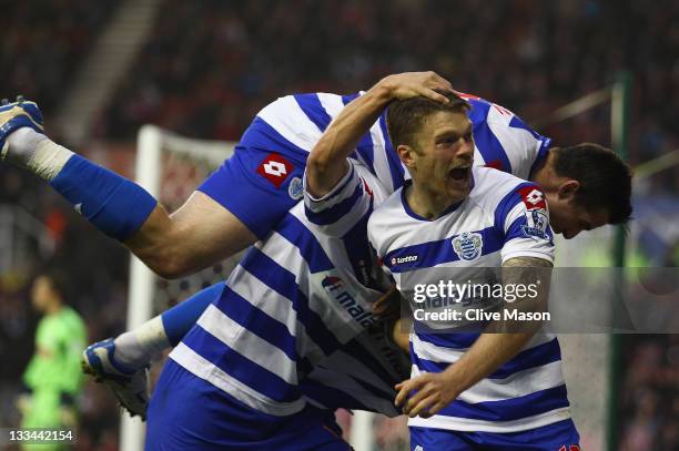 Luke Young of Queens Park Rangers celebrates his goal with team mate Jamie Mackie during the Barclays Premier League match between Stoke City and...
