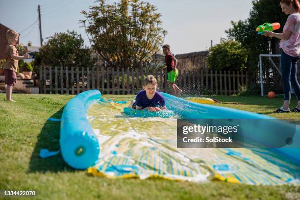 having a water fun day - backyard water slide stock pictures, royalty-free photos & images