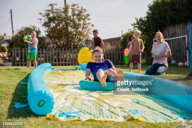 my turn on the slip n slide! - backyard water slide stock pictures, royalty-free photos & images