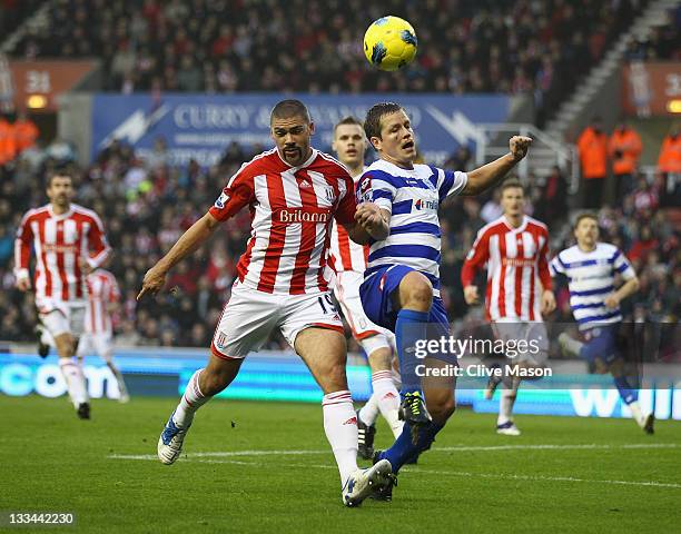 Jonathan Walters of Stoke City is challenged by Heidar Helguson of Queens Park Rangers during the Barclays Premier League match between Stoke City...