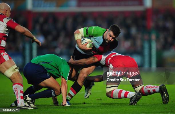 Harlequins forward Nick Easter runs through a tackle from Akapusi Qera and referee Christophe Berdos during the Heineken Cup match between Gloucester...