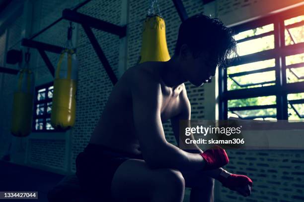 asian young adult boxer feeling negative emotion and sadness after  defeat boxing competition and looking forward - missed train stockfoto's en -beelden