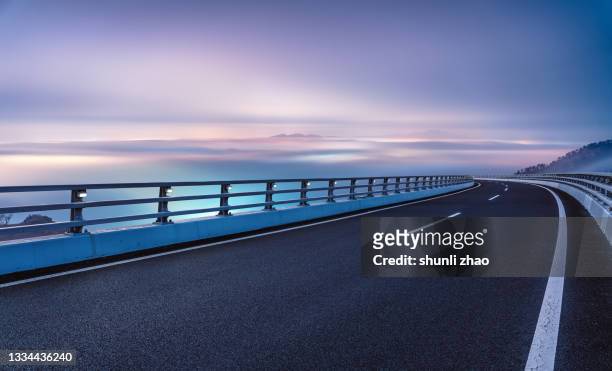 the viaduct that shuttles through the mist in the mountains - perspective road stockfoto's en -beelden