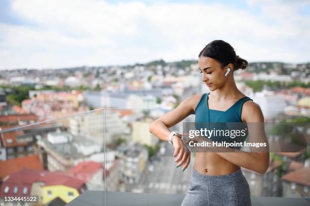 young active woman doing exercise on balcony in city, healthy lifestyle concept. - computador utilizável como acessório imagens e fotografias de stock