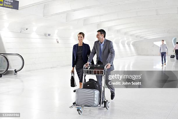 businesspeople walk through airport with luggage - carrito-para-equipaje fotografías e imágenes de stock