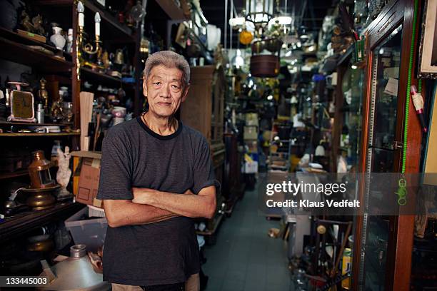 portrait of mature asian second hand dealer - indonesischer archipel stock-fotos und bilder