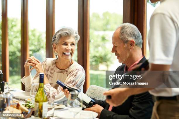 man and woman during winetasting in restaurant - old couple restaurant stock pictures, royalty-free photos & images