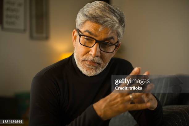 thoughtful mature man at home - one mature man only stock pictures, royalty-free photos & images