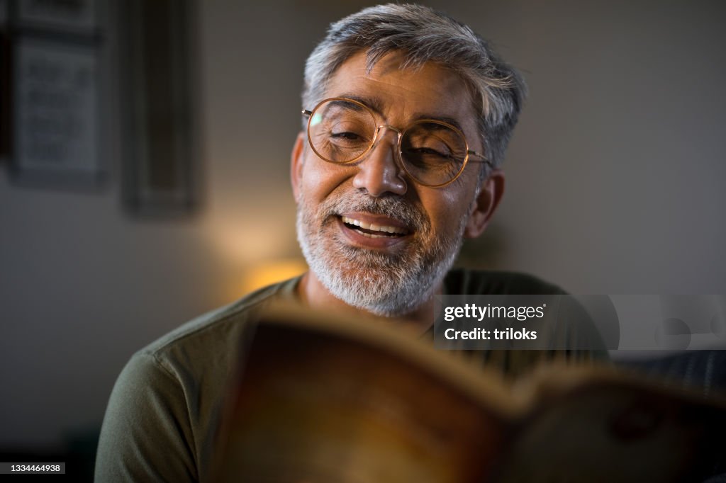 Man reading book at home