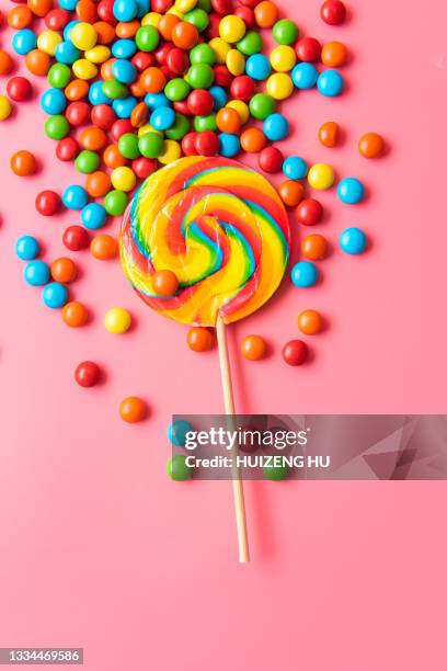 colorful candies and lollipop over pink background - lollipops stock-fotos und bilder