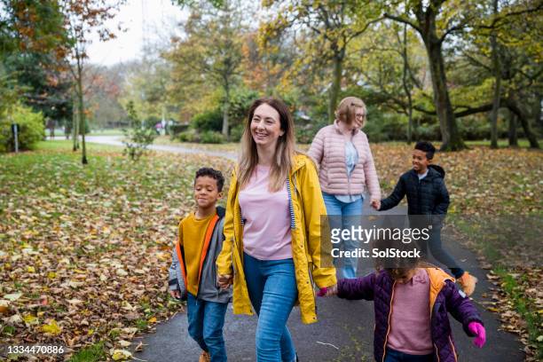 family walking through public park - british culture walking stock pictures, royalty-free photos & images
