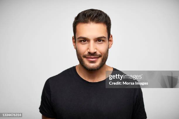 confident hispanic man against white background - black shirt imagens e fotografias de stock