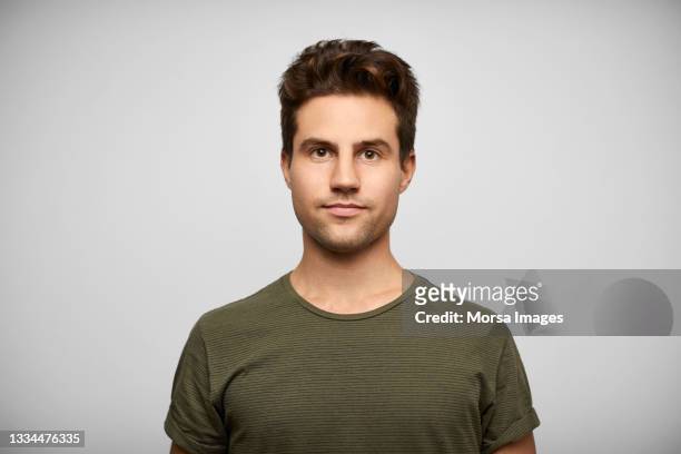 hispanic young man against gray background - handsome man serious tshirt stock-fotos und bilder
