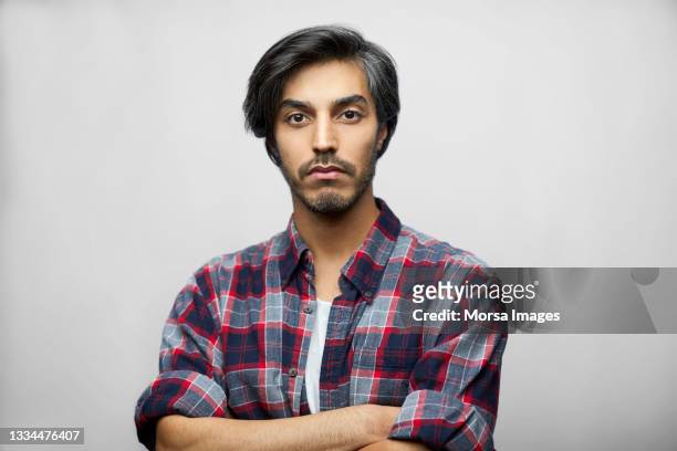 serious latin american man against white background - man wearing plaid shirt stock pictures, royalty-free photos & images