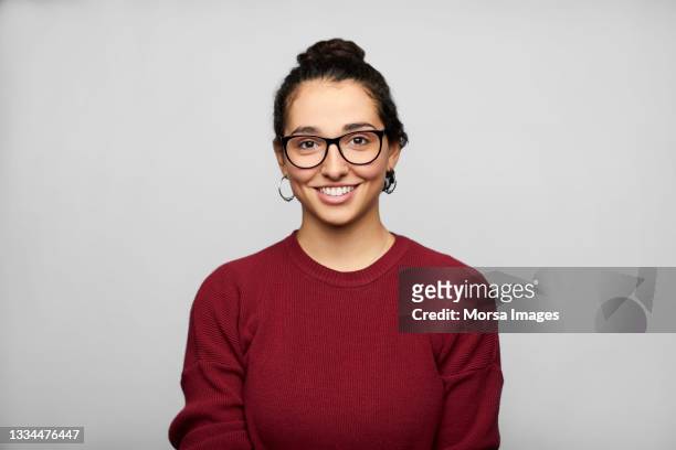 happy latin american woman against gray background - female spectacles stock-fotos und bilder