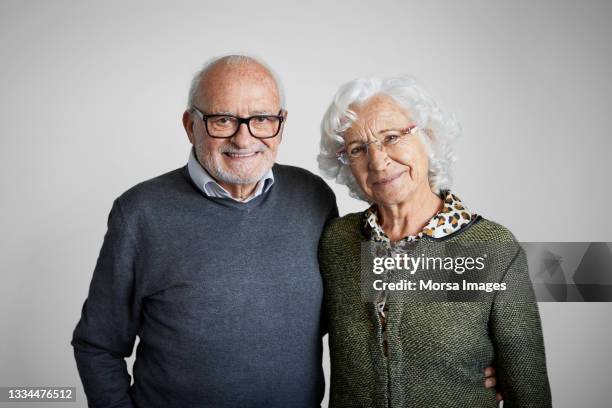 spanish senior couple against gray background - couple sourire studio photos et images de collection