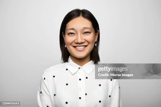 confident chinese businesswoman against white background - primo piano del volto foto e immagini stock