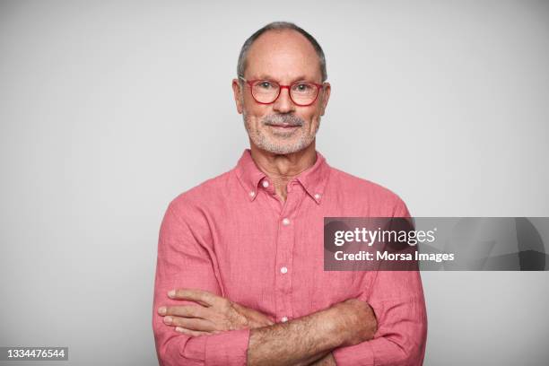 confident elderly male against white background - pink shirt stock-fotos und bilder