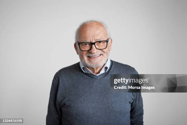spanish senior man in sweater against white background - man expressive background glasses stock pictures, royalty-free photos & images