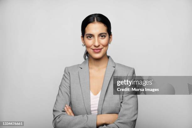 latin american businesswoman in blazer against gray background - graue jacke stock-fotos und bilder