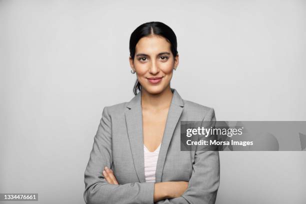 latin american businesswoman in blazer against gray background - ejecutiva fotografías e imágenes de stock