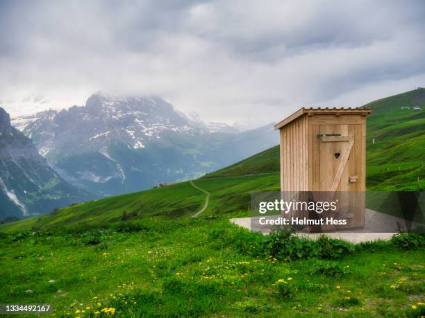 toilet house in the bernese alps near grindelwald - öffentliche toilette stock-fotos und bilder