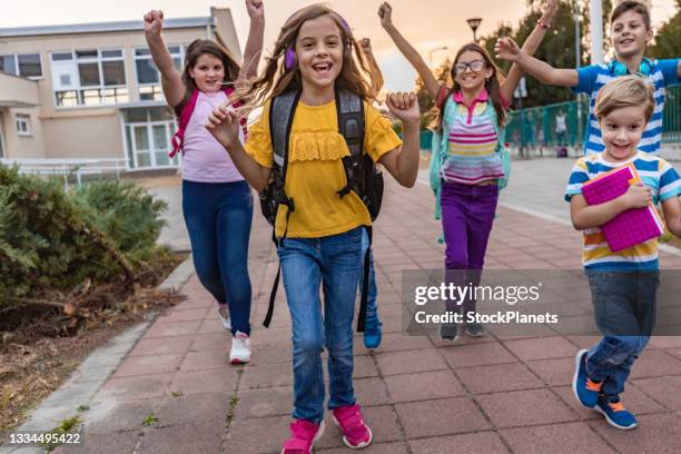 schulkinder laufen auf dem schulhof - first day of school stock-fotos und bilder