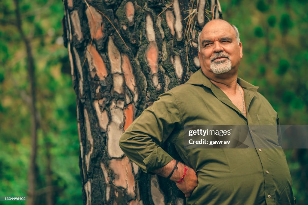 L’homme âgé aime l’air frais dans les bois printanier.