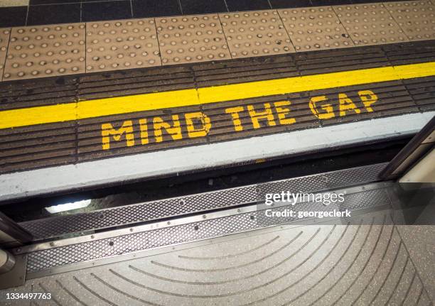 mind the gap-warnung von der londoner u-bahn aus gesehen - separate stock-fotos und bilder