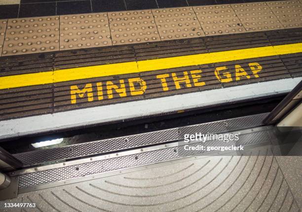 attenzione all'avvertimento di gap visto dal treno della metropolitana di londra - separation foto e immagini stock