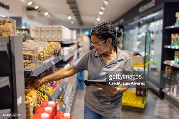 supermarket employee working in the store - conagra general mills brand products on the shelf ahead of earns stockfoto's en -beelden