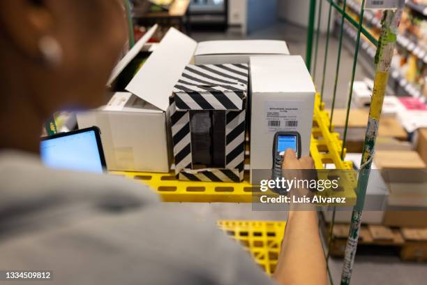 grocery store employee accounting goods in inventory - shopping trolleys stockfoto's en -beelden