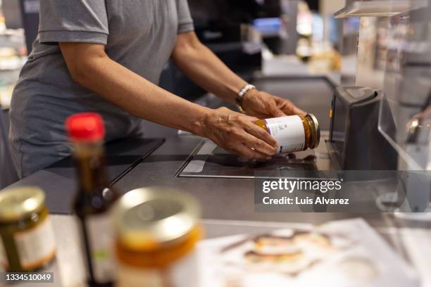 close-up of a supermarket employee scanning products for billing - flat bed scanner stock pictures, royalty-free photos & images