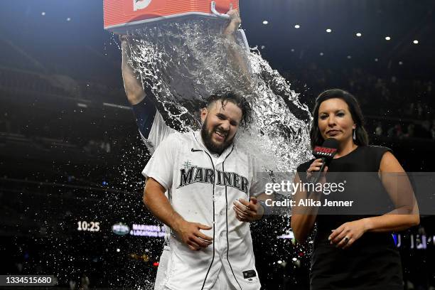 Luis Torrens of the Seattle Mariners gets a Gatorade shower after hitting a walk-off RBI single to win the game in the ninth inning against the Texas...