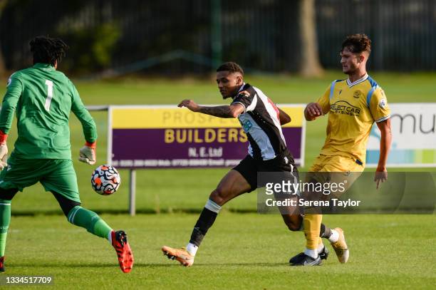 Adam Wilson of Newcastle United crosses the ball as Reading FC Goalkeeper Coniah Boyce-Clarke and Louis Holzman apply pressure during the Premier...