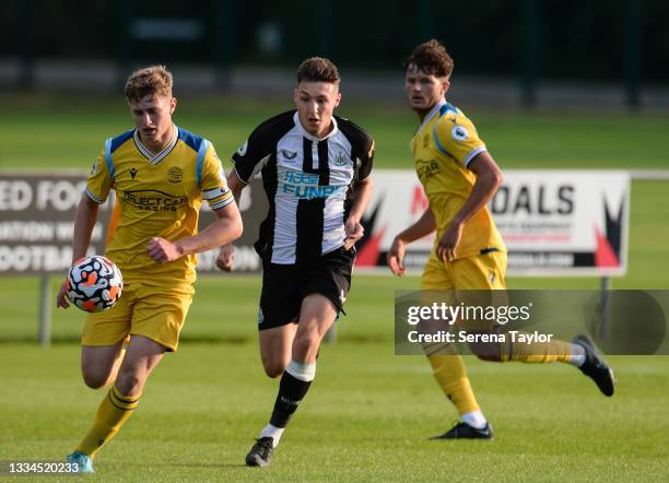 Michael Stickland of Reading FC controls the ball as Dylan Stephenson of Newcastle United applies pressure during the Premier League 2 match between...