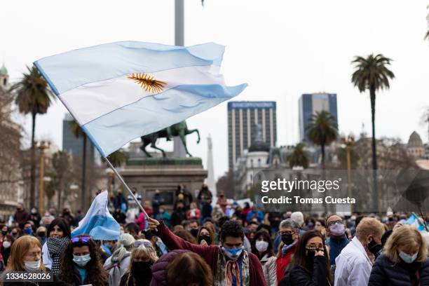 Demonstrator waves an Argentinian flag on the entrance of Casa Rosada during the "Marcha de las piedras" on August 16, 2021 in Buenos Aires,...