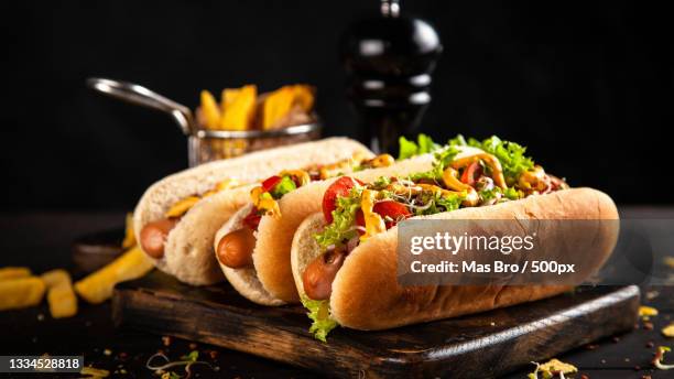 close-up of burgers on serving board against black background - bbq sandwich stockfoto's en -beelden