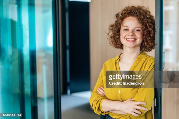 portrait of a smiling young curly woman - young women only stock pictures, royalty-free photos & images