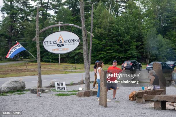 people enjoying their drink at front yard at sticks & stones restaurant - schroon lake stock pictures, royalty-free photos & images