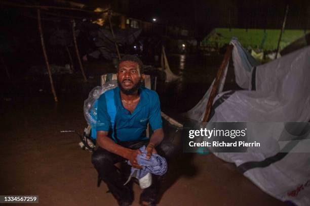 Man looks on as Tropical Storm Grace hits a refugee camp at a football field called Parc Lande de Gabion after a 7.2-magnitude earthquake struck...