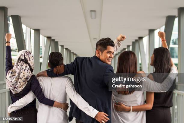 rückansicht des diversen business-teams standing together, ein mann schaut über die schulter - hijab woman from behind stock-fotos und bilder