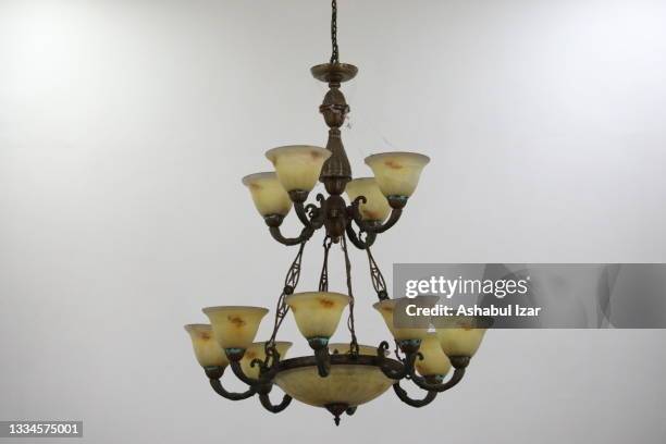 an old chandelier in a building against a white wall - ceiling lamp stock pictures, royalty-free photos & images