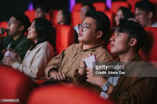 asiatico cinese misto età gruppo di pubblico guardando film seduto di fila nel cinema cinema godendo - prima cinematografica foto e immagini stock