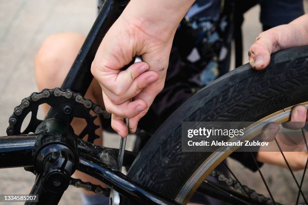 a boy is repairing a bicycle. dirty hands of a child tighten a screw or nut, repair a child's vehicle. the concept of hobbies and entertainment, doing what you love. happy sports childhood and summer holidays. - happy holidays family stock pictures, royalty-free photos & images