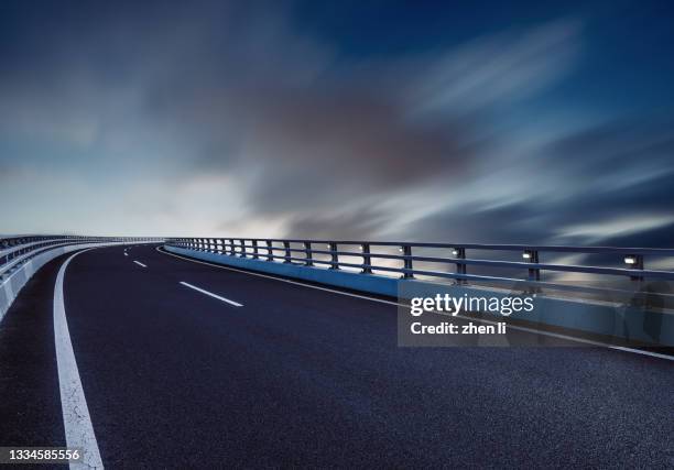 elevated road against cloud sky at night - route surélevée photos et images de collection