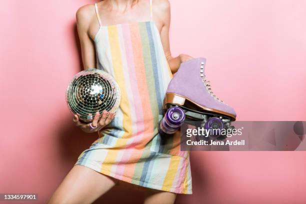 retro 1970s woman holding rollerskates and disco ball - disco dancer stock pictures, royalty-free photos & images