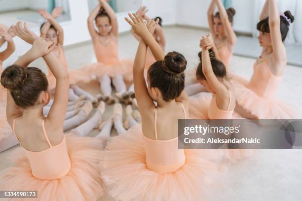 kleine ballerinas wärmen sich für eine ballettstunde auf - little ballet stock-fotos und bilder