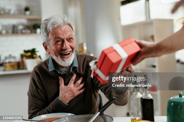 porträt eines älteren mannes mit geschenk. - geburtstagsgeschenk stock-fotos und bilder